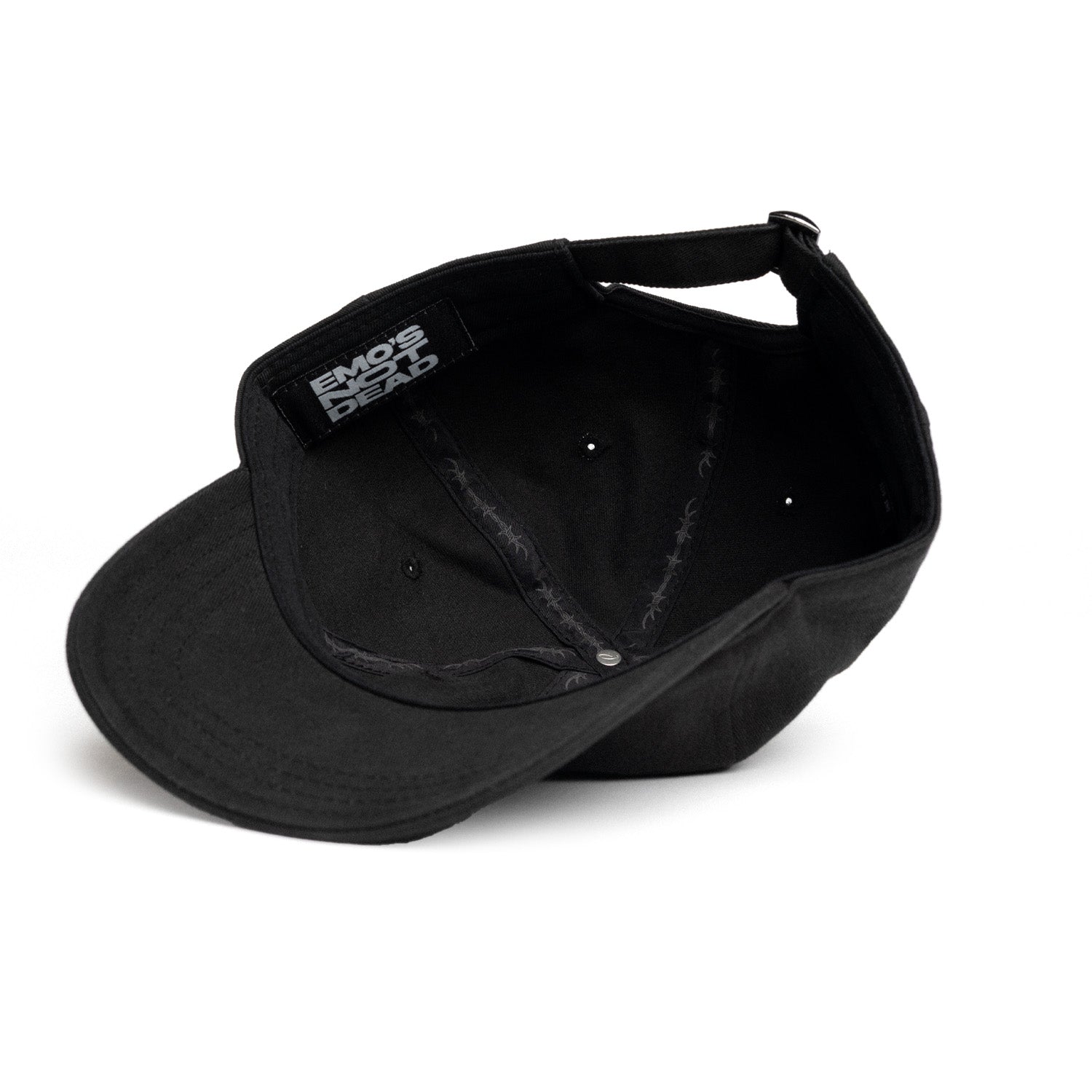 A black baseball cap shown from an angled top-down view, featuring a black fabric patch on the side with the white text &